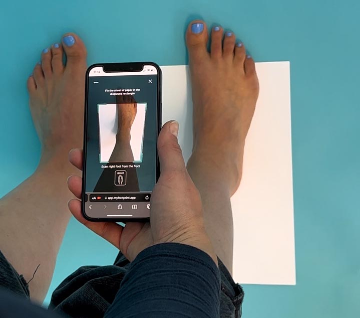 Person misst mit Smartphone und Footprint seine Füße